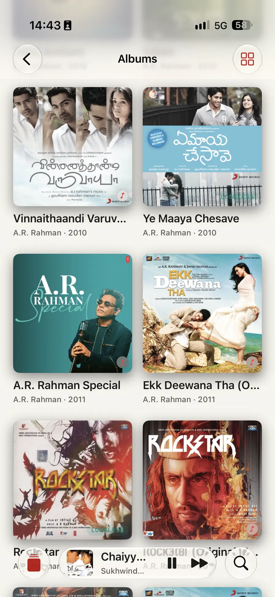Isai&rsquo;s Albums grid on iPhone: artwork for Vinnaithaandi Varuvaayaa, Ye Maaya Chesave, A.R. Rahman Special, Ekk Deewana Tha and two Rockstar releases, each under its artist and year, with LOSSLESS marked on the copies that are, and a mini player along the bottom playing Chaiyya Chaiyya by Sukhwinder Singh.